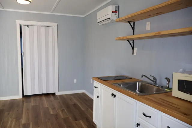 a kitchen that has a sink cabinets and wooden floor