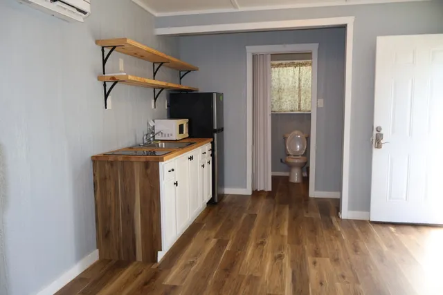 a kitchen with a sink and wooden floor