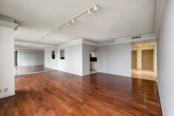 a view of empty room with wooden floor