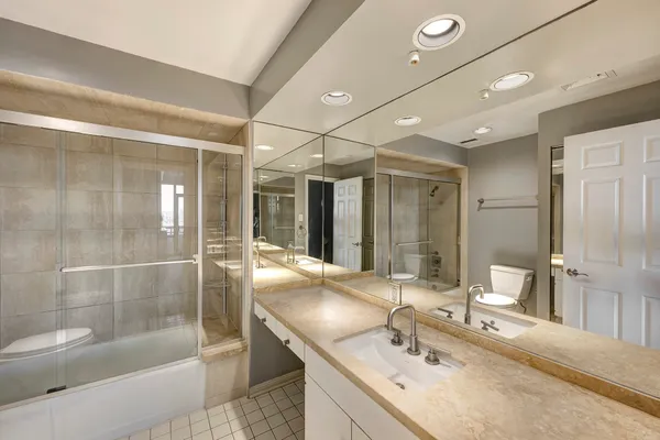 a bathroom with a granite countertop sink mirror and shower