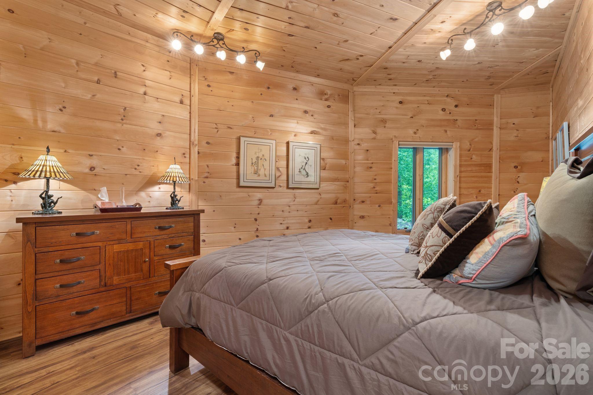 140 Slim Ridge Maggie Valley, NC 28751 - Photo 20 of 33 a bedroom with a bed and a dresser with the wooden floor
