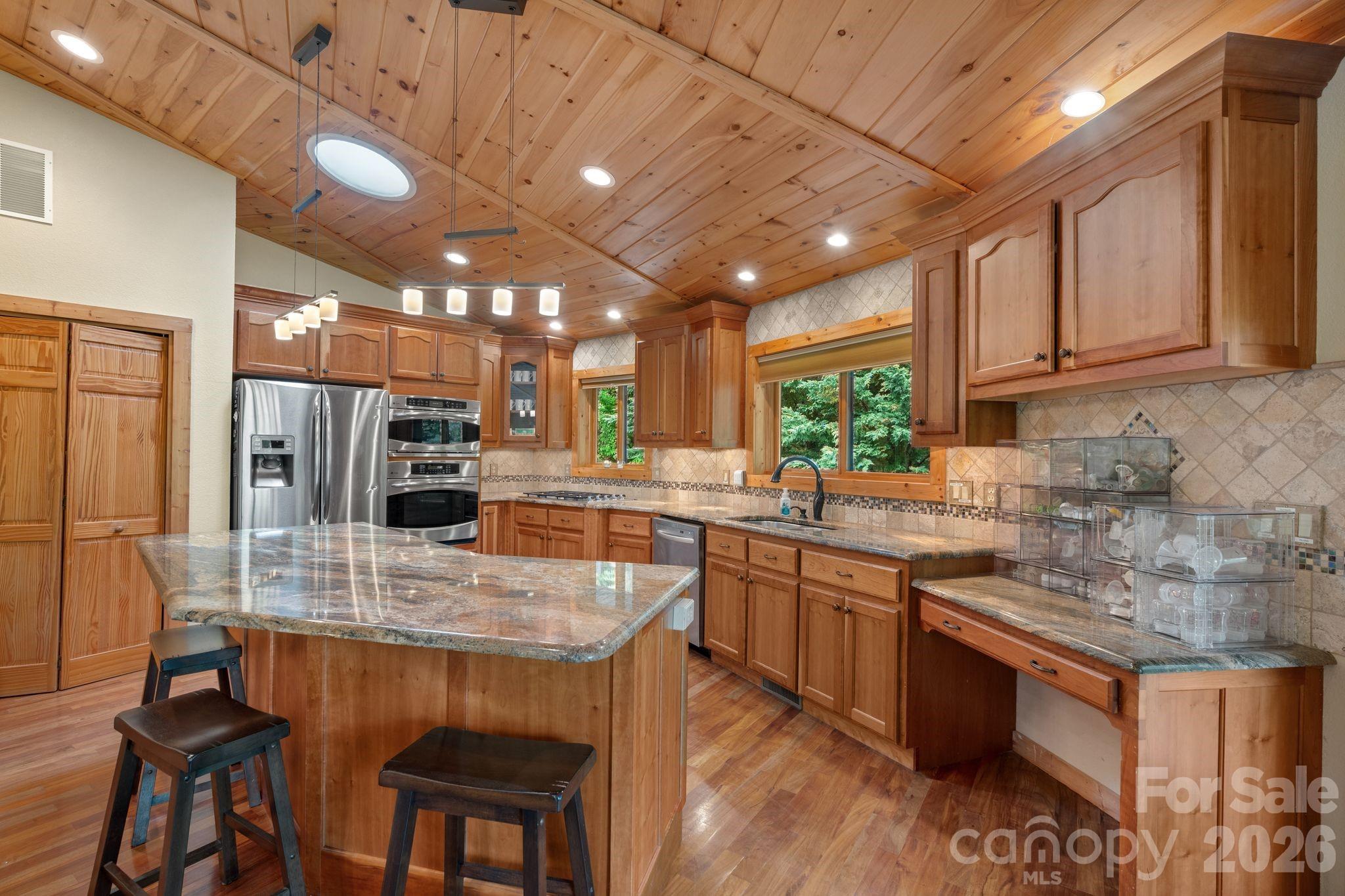 140 Slim Ridge Maggie Valley, NC 28751 - Photo 5 of 33 a kitchen with stainless steel appliances granite countertop table chairs sink and cabinets