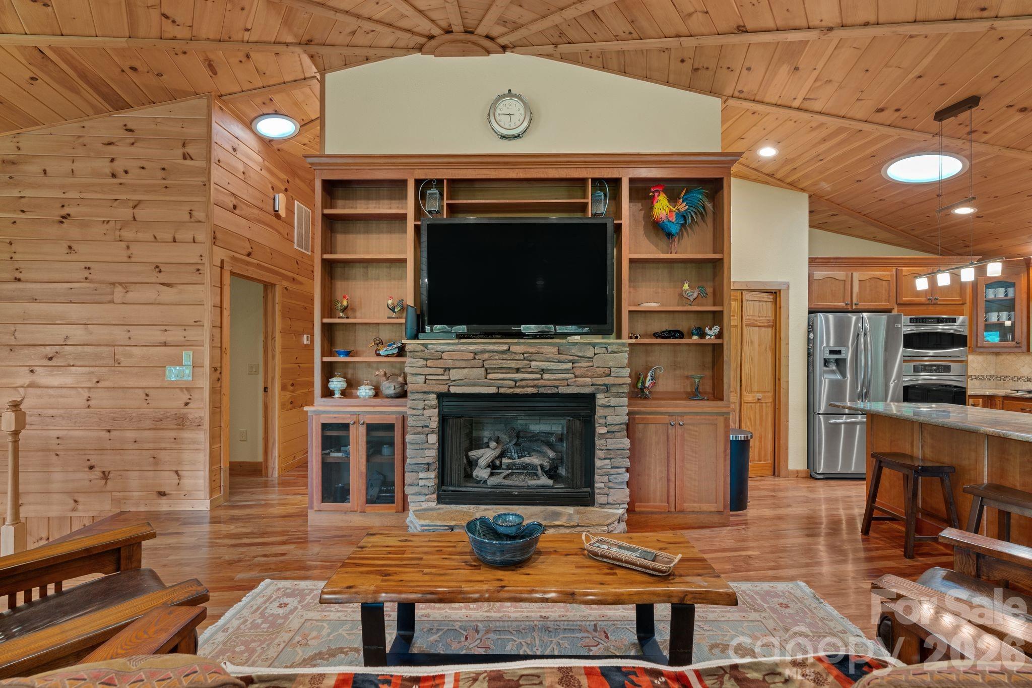 140 Slim Ridge Maggie Valley, NC 28751 - Photo 7 of 33 a living room with a fireplace a flat screen tv and outdoor seating