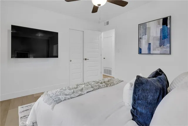 a bedroom with a bed a flat screen tv and wall