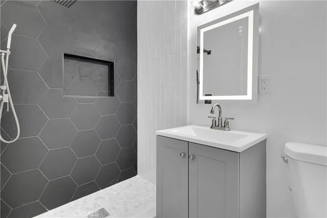 a bathroom with a sink a toilet and a mirror