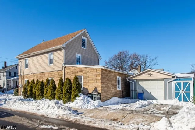 a view of a house with snow on the side of road