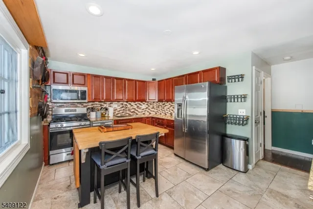 a kitchen with stainless steel appliances granite countertop a refrigerator and a sink