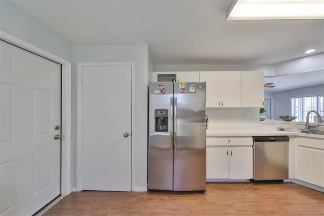 a kitchen with stainless steel appliances a refrigerator sink and cabinets