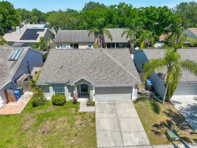 an aerial view of residential houses with outdoor space and trees