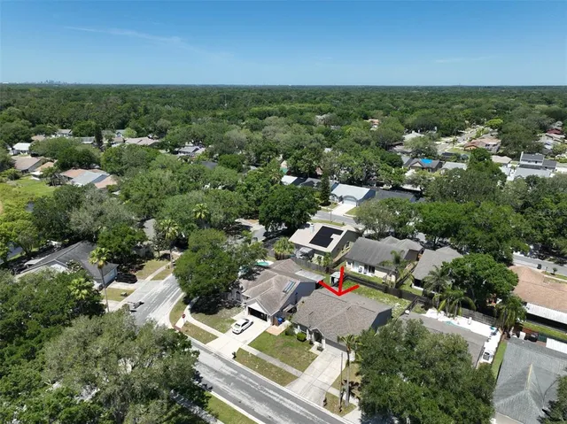 an aerial view of residential houses with outdoor space and trees
