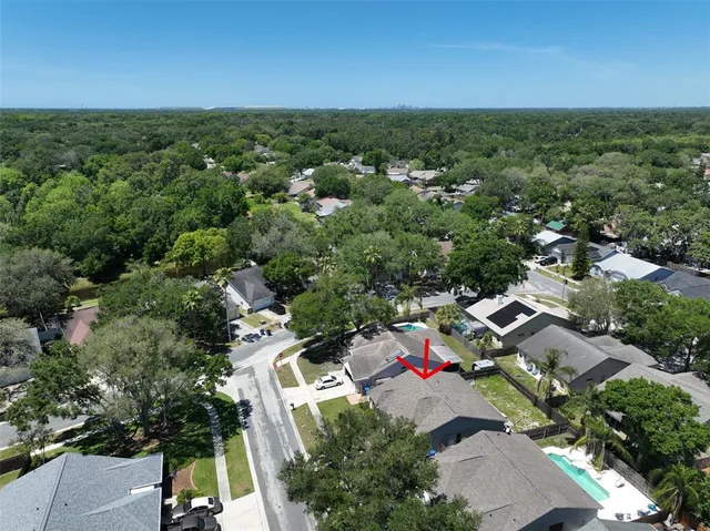 an aerial view of residential houses with outdoor space and trees