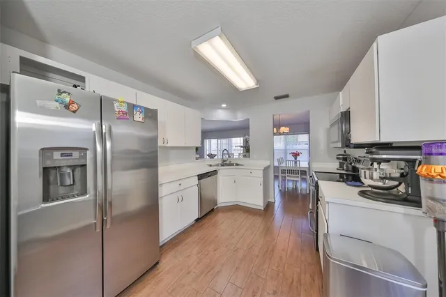 a kitchen with refrigerator a sink dishwasher a refrigerator and cabinets with wooden floor