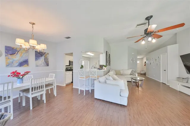 a living room with furniture dining table and wooden floor