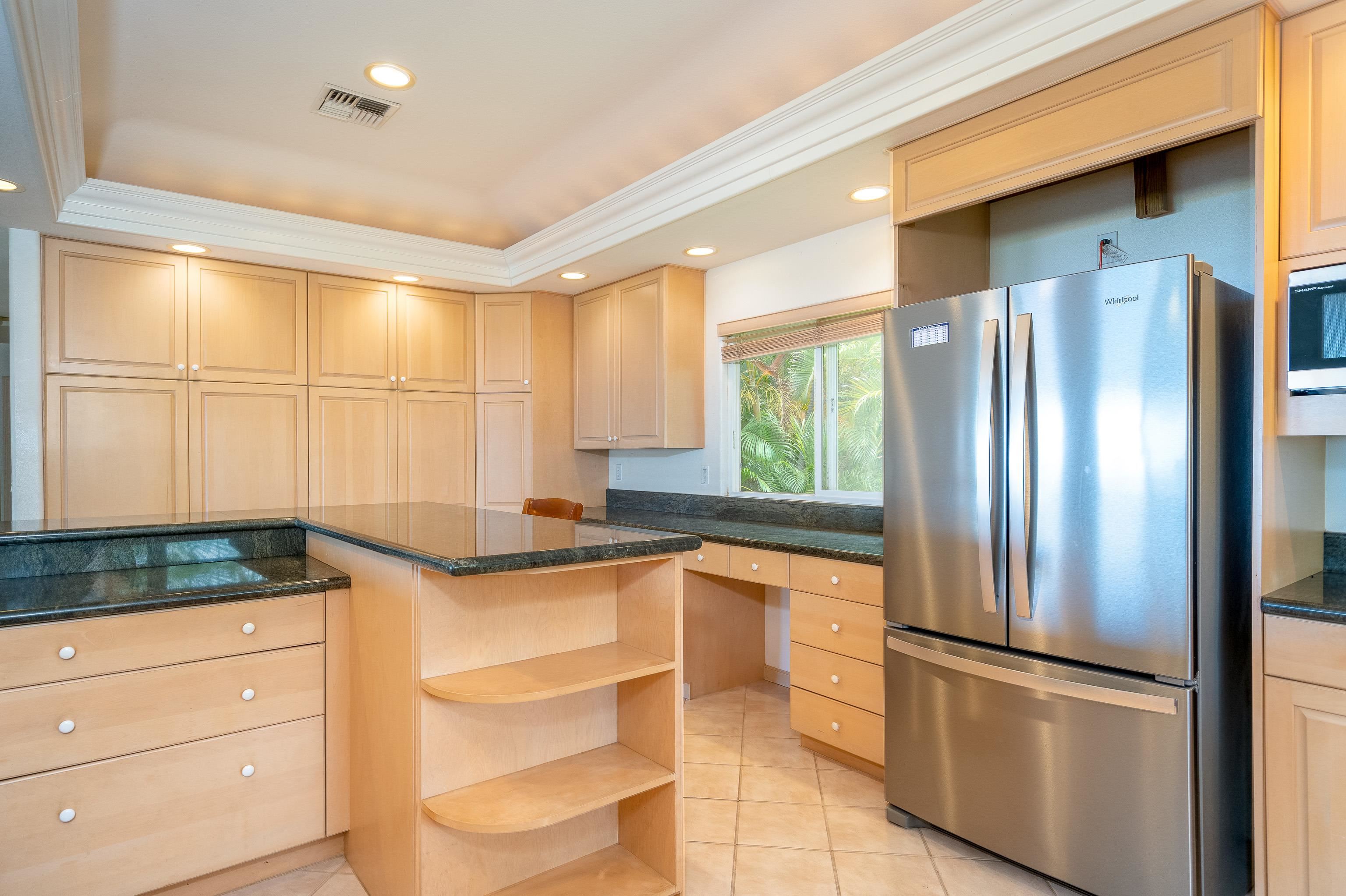 216 Kamakoi Loop Kihei, HI 96753 - Photo 24 of 30 a kitchen with stainless steel appliances granite countertop a refrigerator and a sink