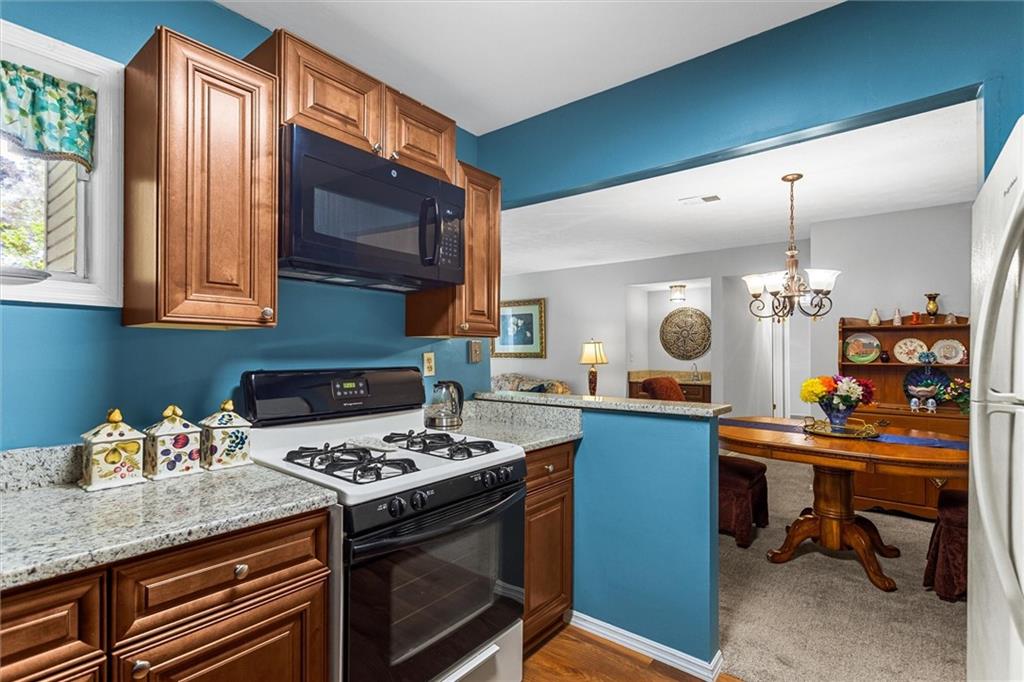 1610 Raleigh Circle Marietta, GA 30067 - Photo 14 of 33 a kitchen with a stove and a wooden cabinets