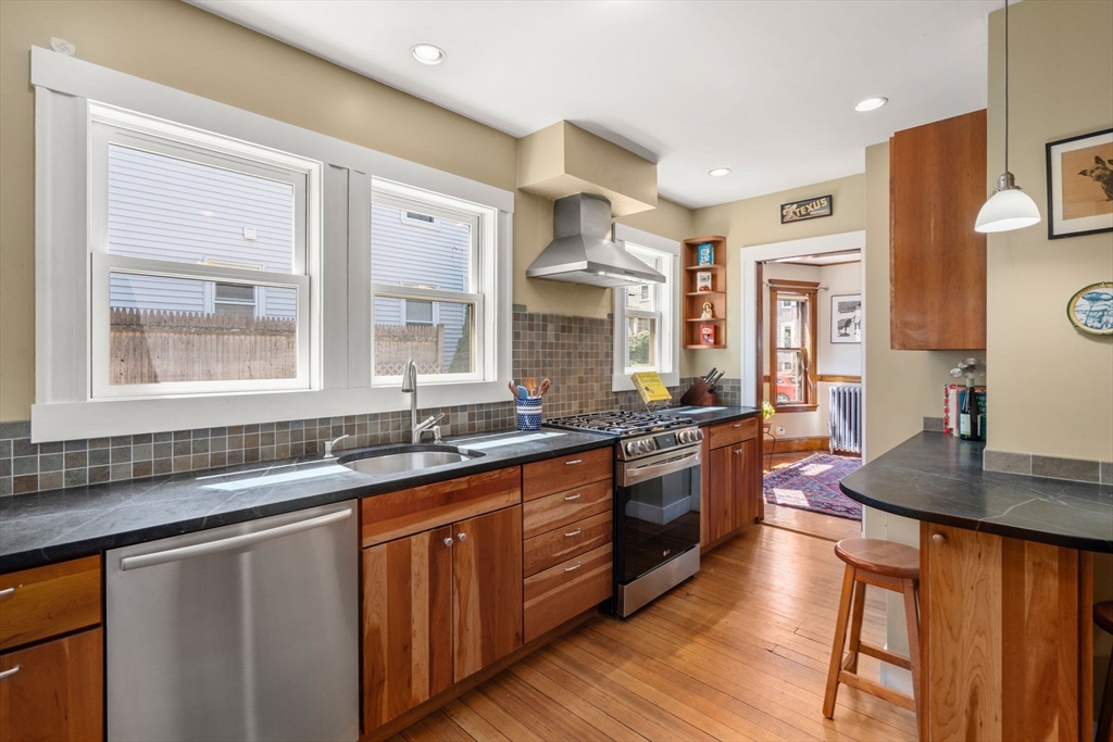 45 Springfield Street, Unit 1 Belmont, MA 02478 - Photo 11 of 27 a kitchen with stainless steel appliances granite countertop a sink stove and wooden cabinets