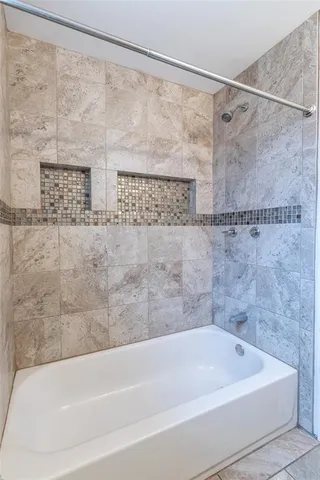 a bathroom with a shower and a bath tub