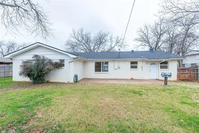 a front view of house with yard and trees in the background