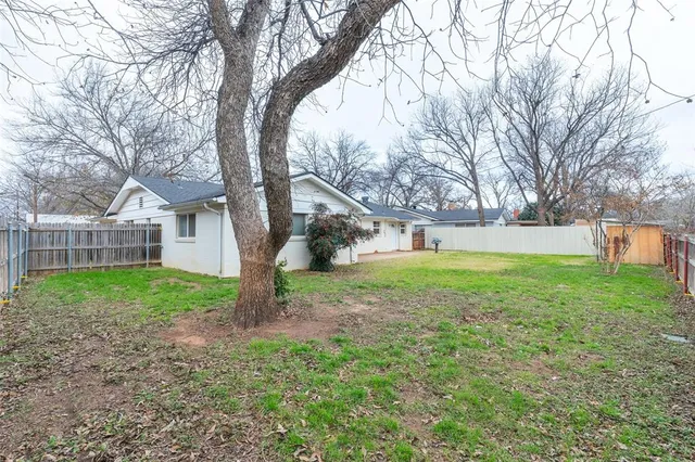 a view of a house with backyard and a tree