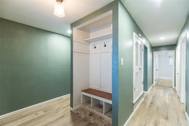 a view of a hallway with wooden floor and staircase