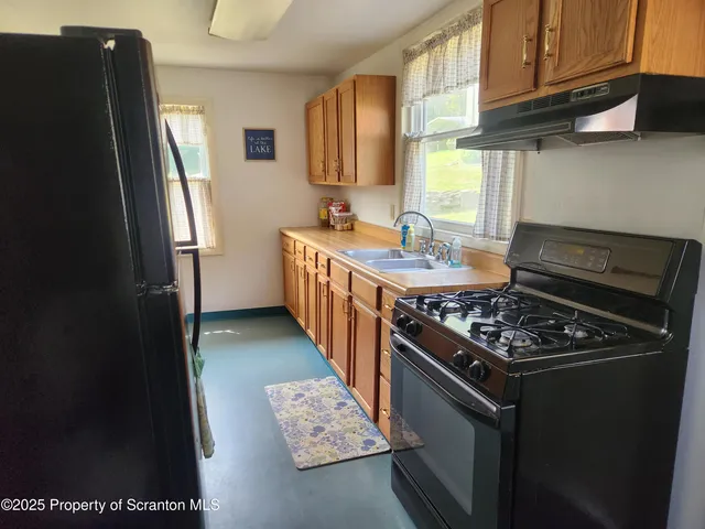 a kitchen with stainless steel appliances granite countertop a stove a refrigerator and a sink