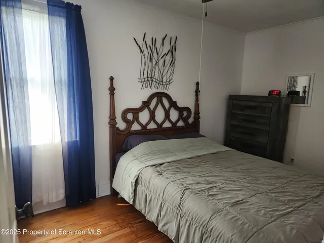 a bed sitting in a bedroom next to a window and dresser