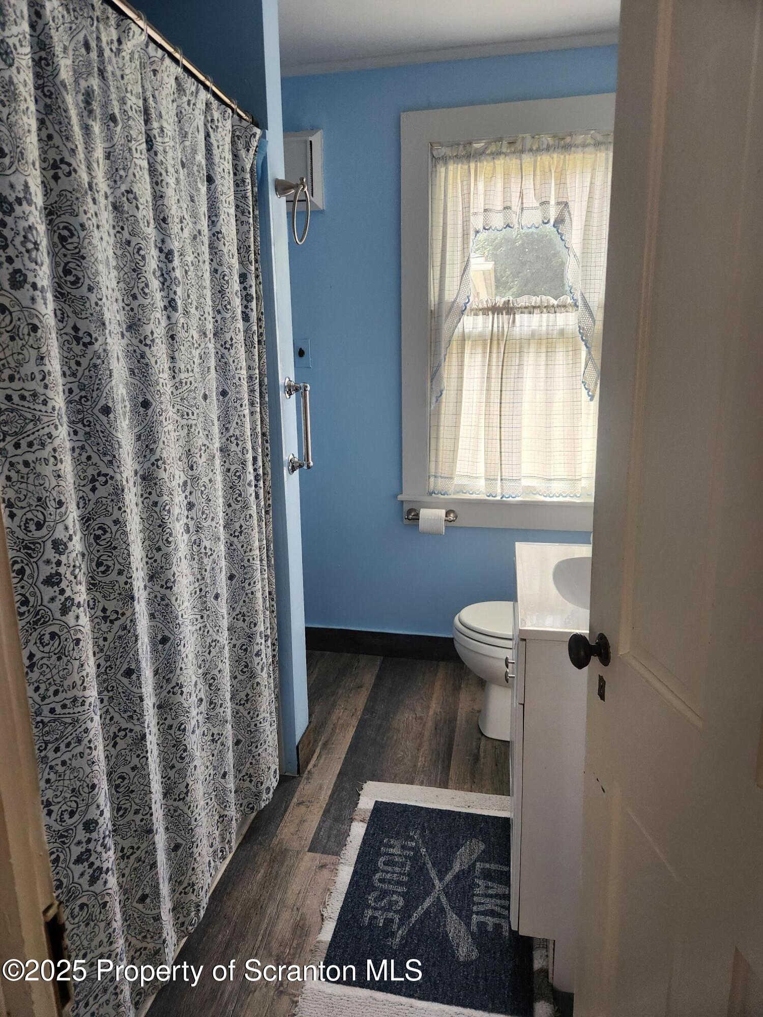 135 Pedrick Road Nicholson, PA 18446 - Photo 9 of 16 a bathroom with a toilet and a shower curtain