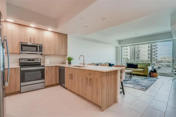 a kitchen with stainless steel appliances kitchen island granite countertop a stove a sink and a refrigerator