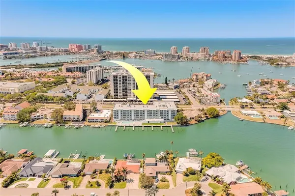 an aerial view of ocean and residential houses with outdoor space