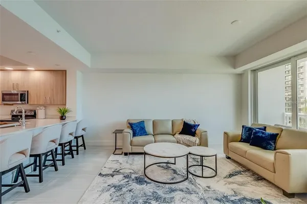 a living room with furniture and a dining table with kitchen view