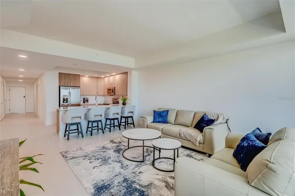 a kitchen with kitchen island a dining table chairs stainless steel appliances and cabinets