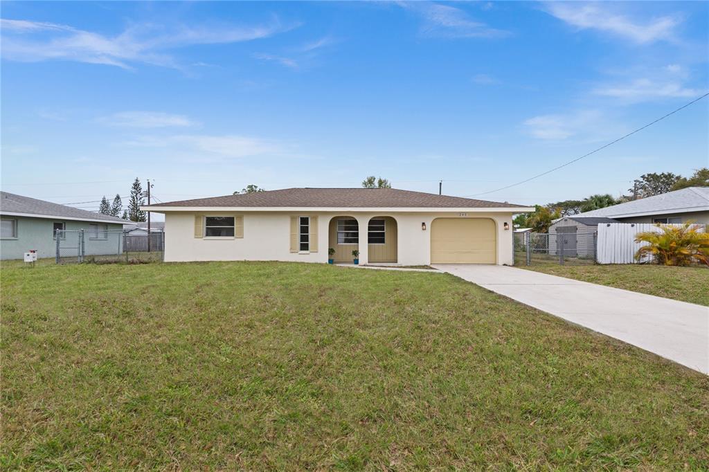 a front view of house with yard and trees in the background
