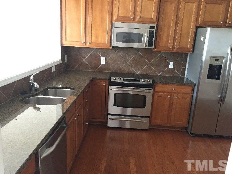 8215 Pilots View Drive Raleigh, NC 27617 - Photo 5 of 18 a kitchen with stainless steel appliances granite countertop a stove a microwave and a sink
