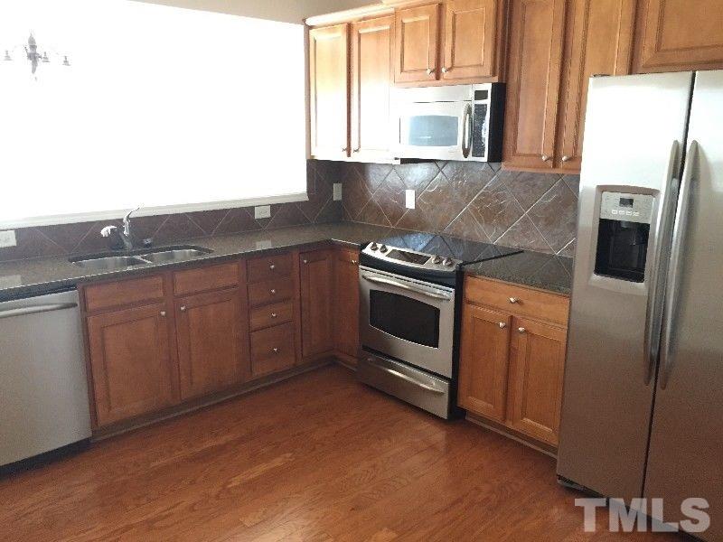 8215 Pilots View Drive Raleigh, NC 27617 - Photo 6 of 18 a kitchen with stainless steel appliances granite countertop a stove a sink and a refrigerator