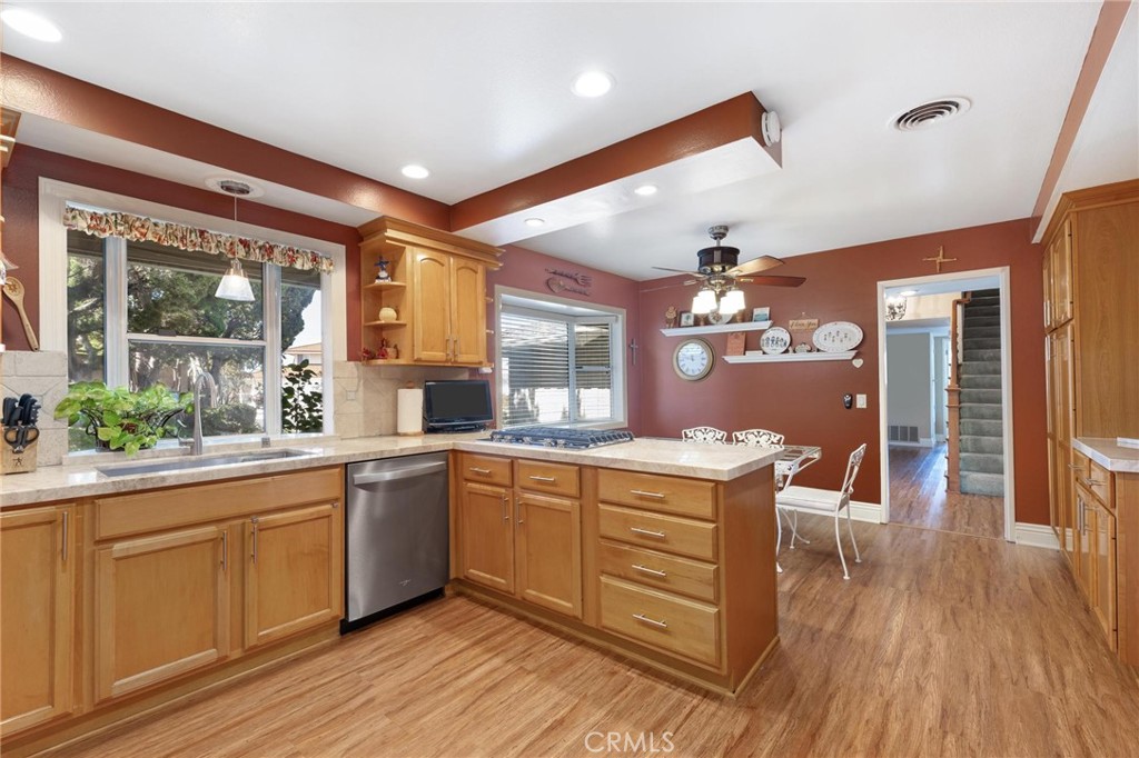 12110 Braemore Place Porter Ranch, CA 91326 - Photo 15 of 45 a kitchen with stainless steel appliances granite countertop hardwood floor sink stove dining table and chairs
