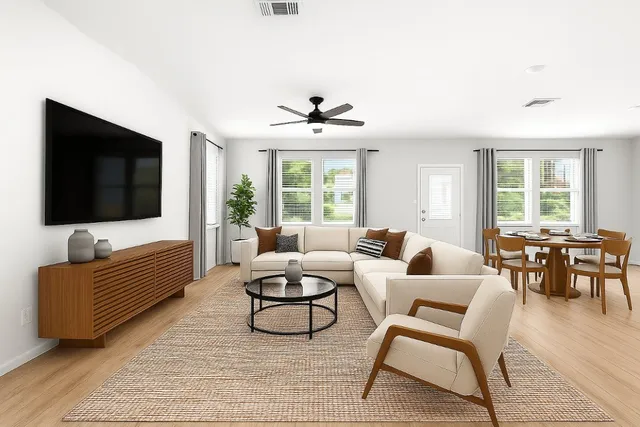 a living room with furniture a flat screen tv and a large window