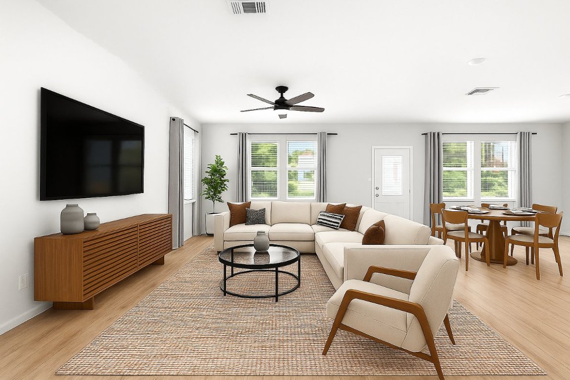 a living room with furniture a flat screen tv and a large window