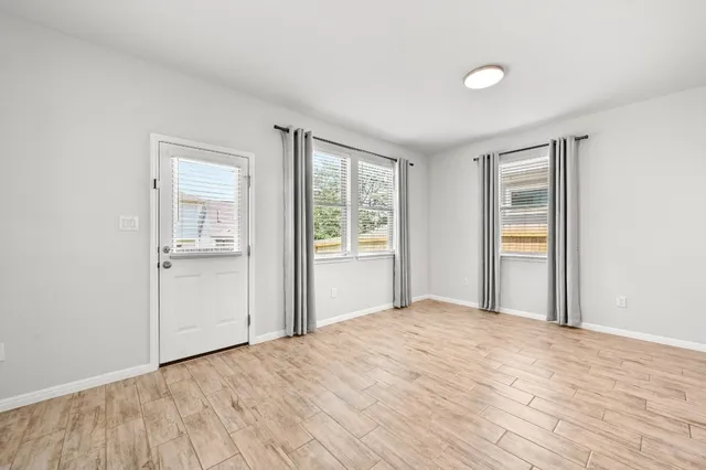 a view of a livingroom with wooden floor and a window