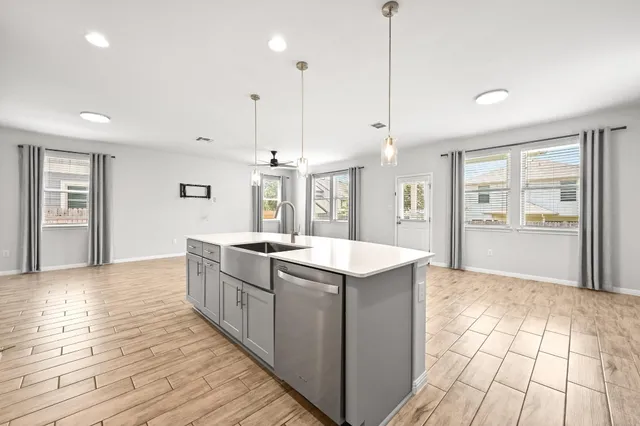 a kitchen with stainless steel appliances granite countertop a sink and wooden floor