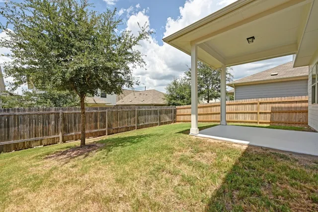 a view of backyard with wooden fence
