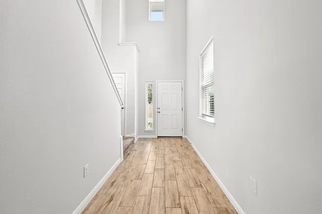 a view of a hallway with wooden floor and staircase