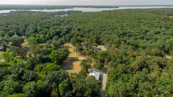 an aerial view of residential houses with outdoor space and trees