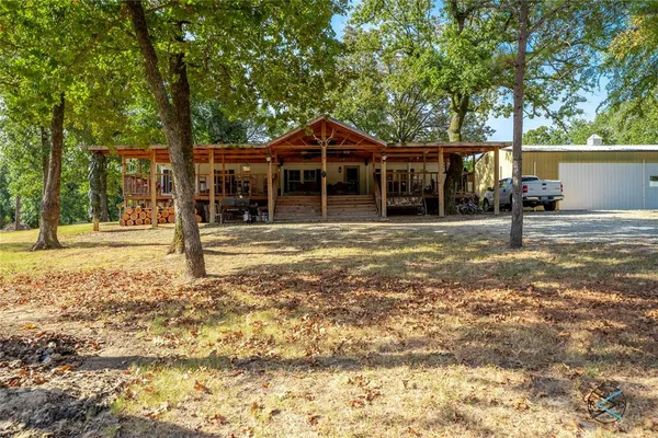 a view of a house with backyard and tree