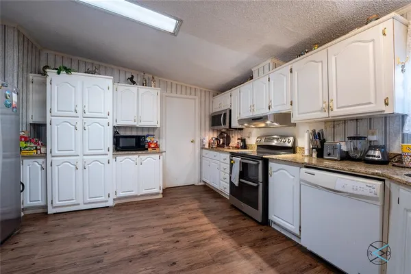 a kitchen with cabinets appliances and a window