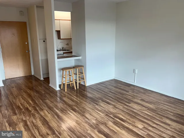 a view of a room with wooden floor and a window