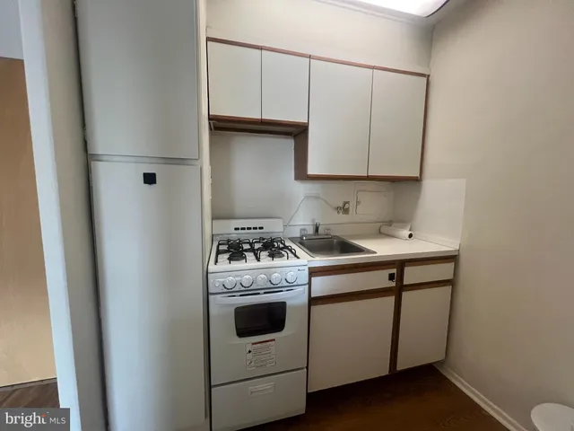 a kitchen with a stove sink and cabinets