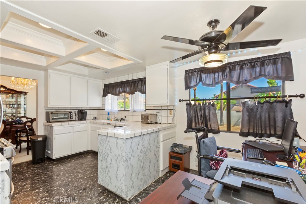 7055 Mango Street Rancho Cucamonga, CA 91701 - Photo 11 of 32 a kitchen filled with a white stove top oven a sink a dining table and chairs