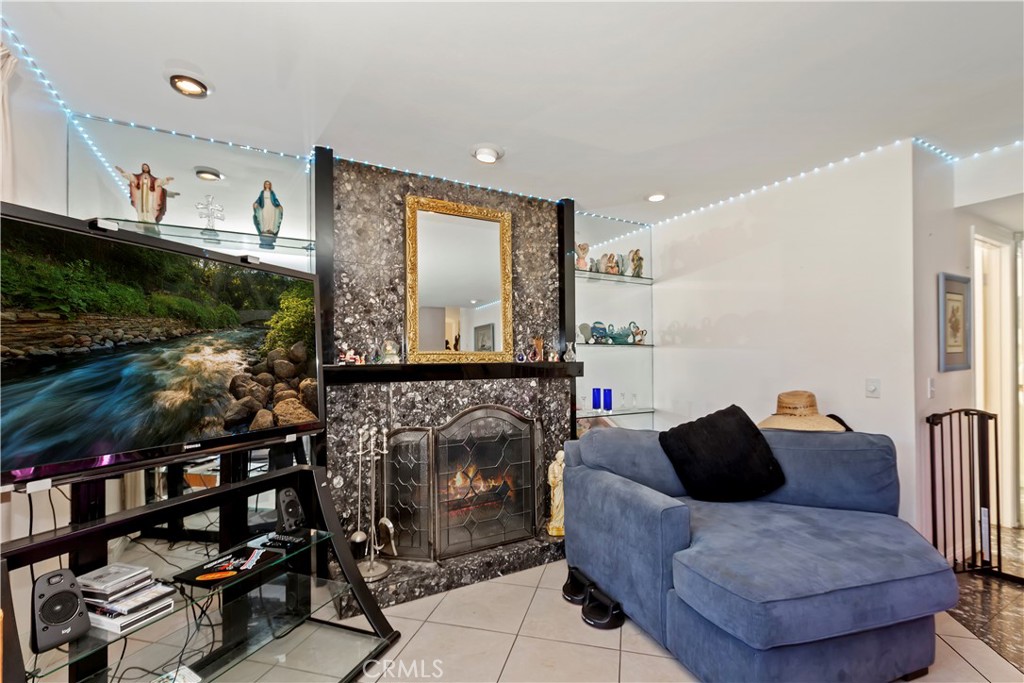 7055 Mango Street Rancho Cucamonga, CA 91701 - Photo 14 of 32 a living room with furniture a flat screen tv and a fireplace