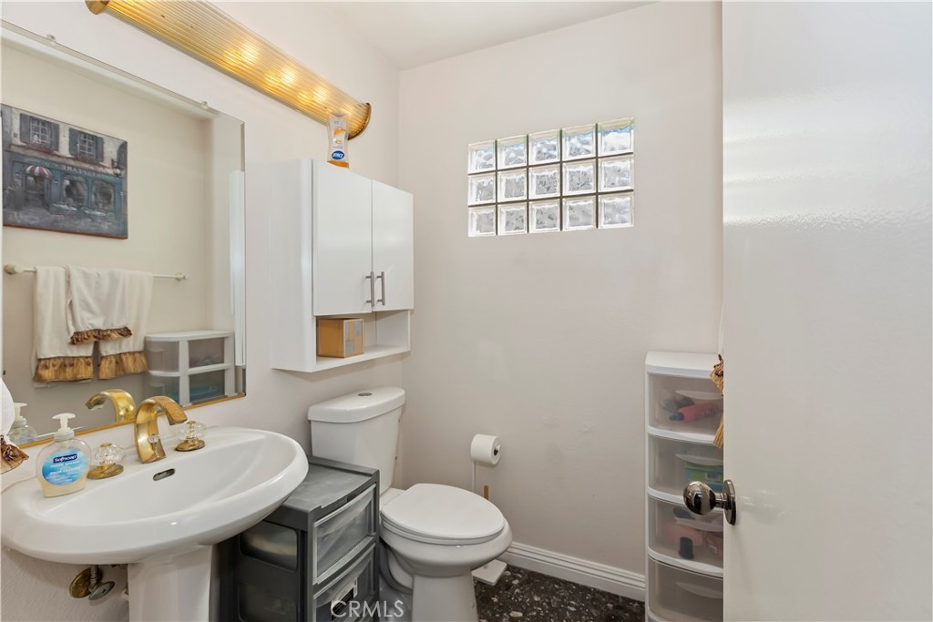 7055 Mango Street Rancho Cucamonga, CA 91701 - Photo 16 of 32 a bathroom with a sink a toilet and mirror