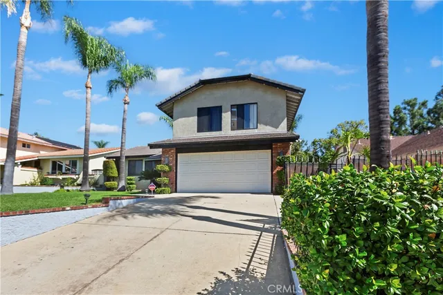 a front view of a house with a yard and potted plants